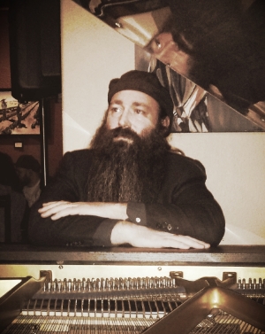 Dustin Adams behind an open piano