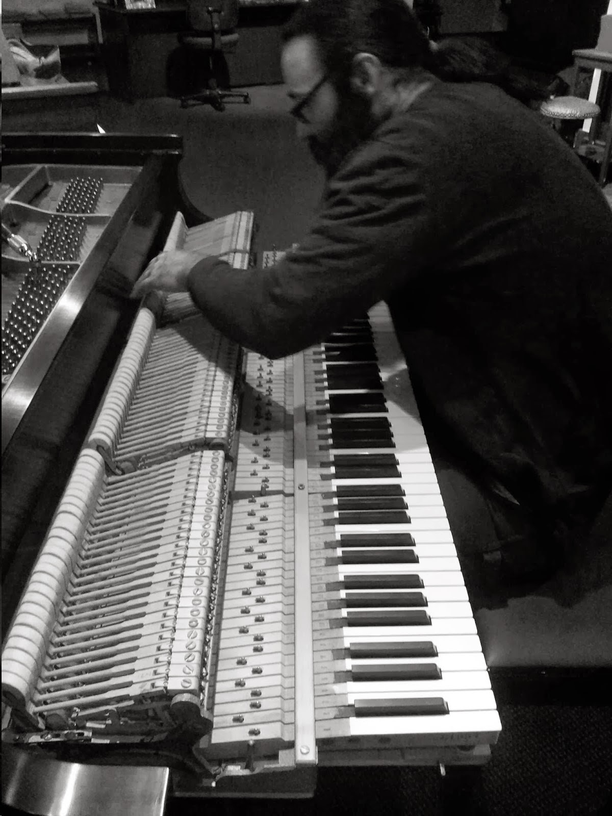 Dustin Adams working inside an exposed piano action