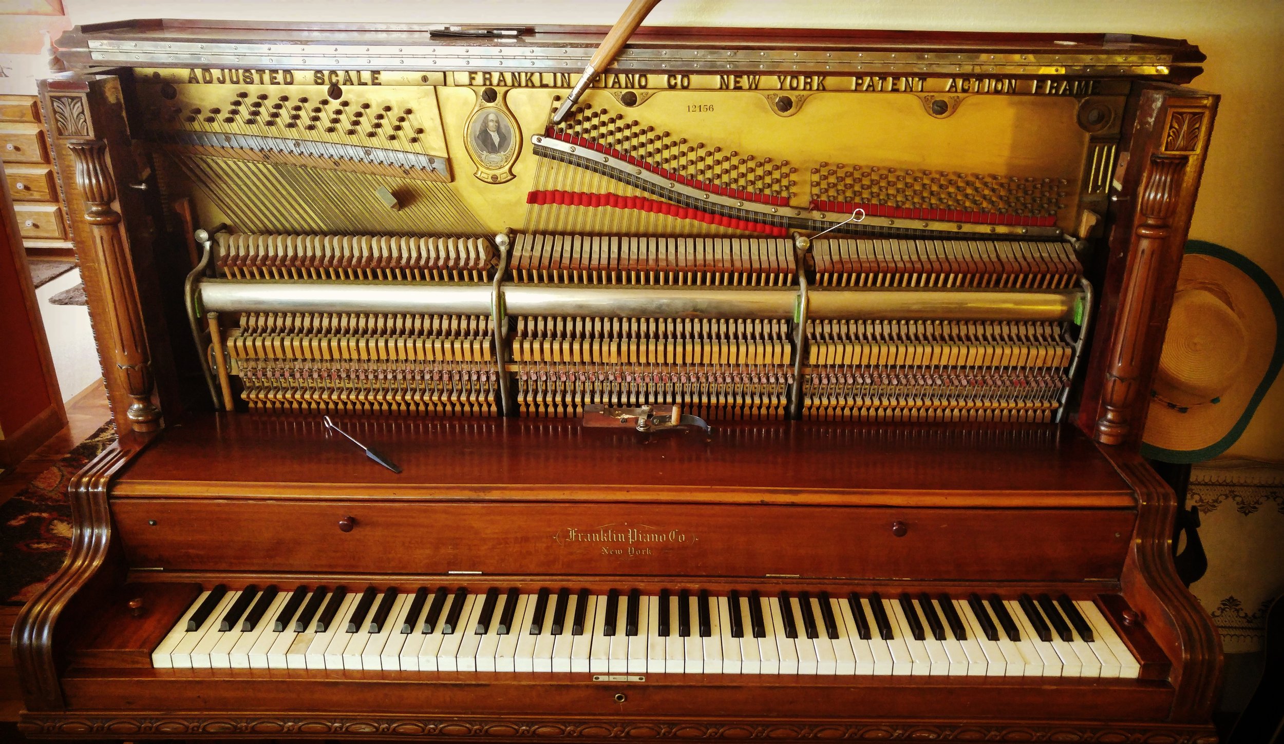 Exposed upright piano action showing hammers, dampers, and keys